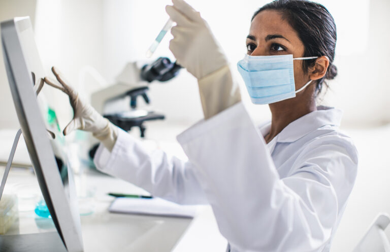 Female healthcare professional working in a laboratory and using various healthcare systems.