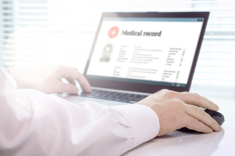 Doctor using a laptop in a hospital setting to access his patient records.