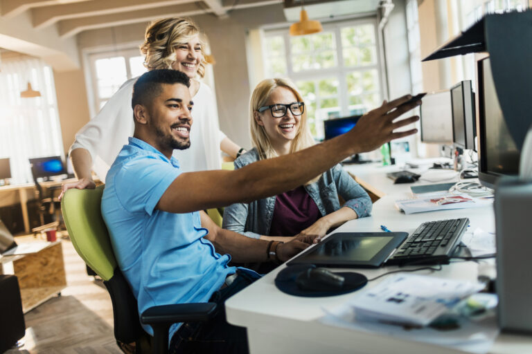 Group of employees in an office using a computer to access the new Microsoft Windows 11 operating system.