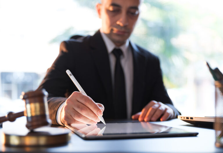 Male lawyer using a tablet computer in his office - an idea of strengthening cybersecurity measures for law companies.