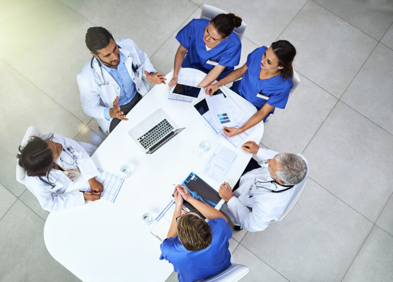 Group of medical professionals in an office having a meeting about their facility's business continuity management.