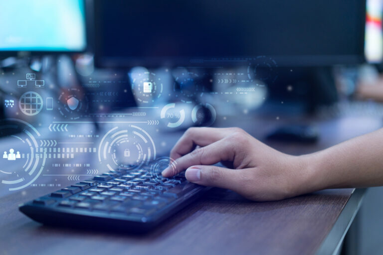 Using Microsoft Defender - Hand of a person typing on a computer keyboard, showing computer security icons.