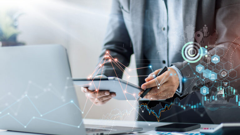 ITSM reporting - Businessman using a laptop and digital tablet to generate IT reports.