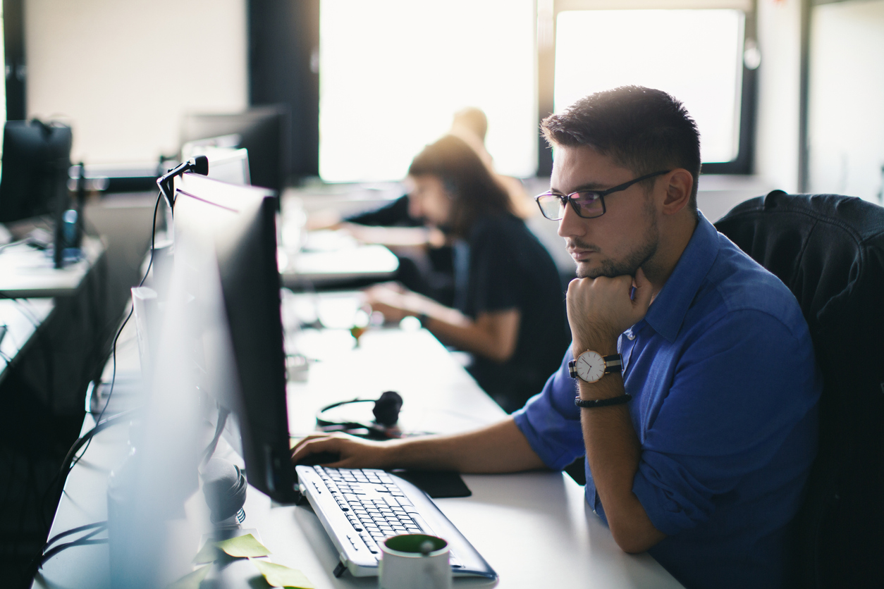 Male employee using a computer in an office during a cybersecurity awareness training.