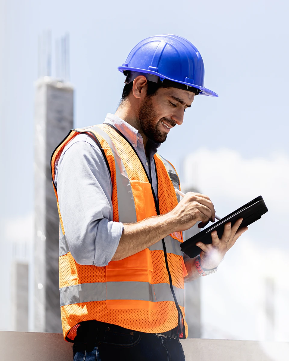 mobile device management for construction companies construction worker on a mobile device out in the field at a construction project