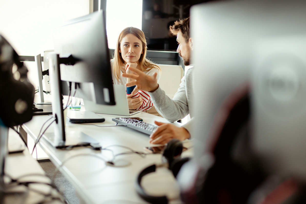 Male IT professional having a discussion with a female employee about using company hardware.