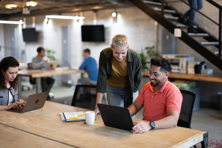 Benefits of a shared network drive - Employees in an office accessing company documents using different laptops.