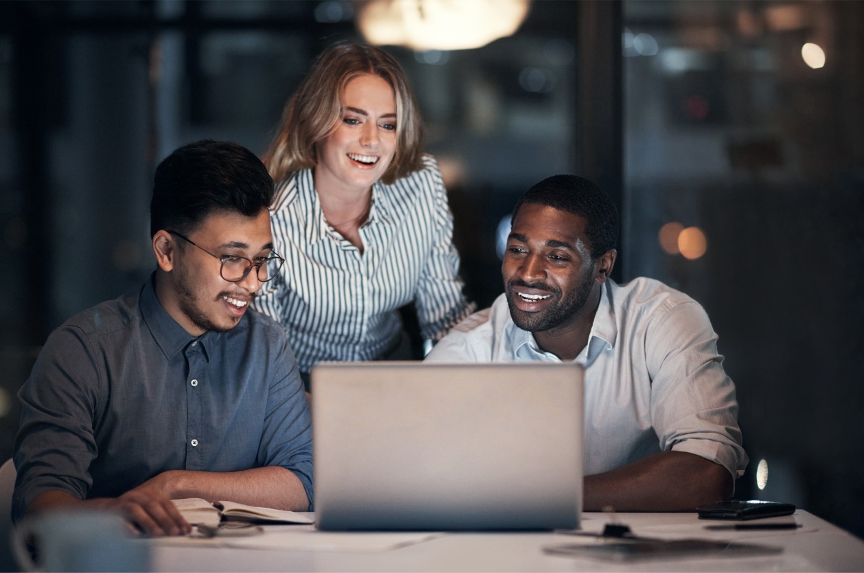 Advantages of a shared network drive - Three project managers using a computer to access company files.