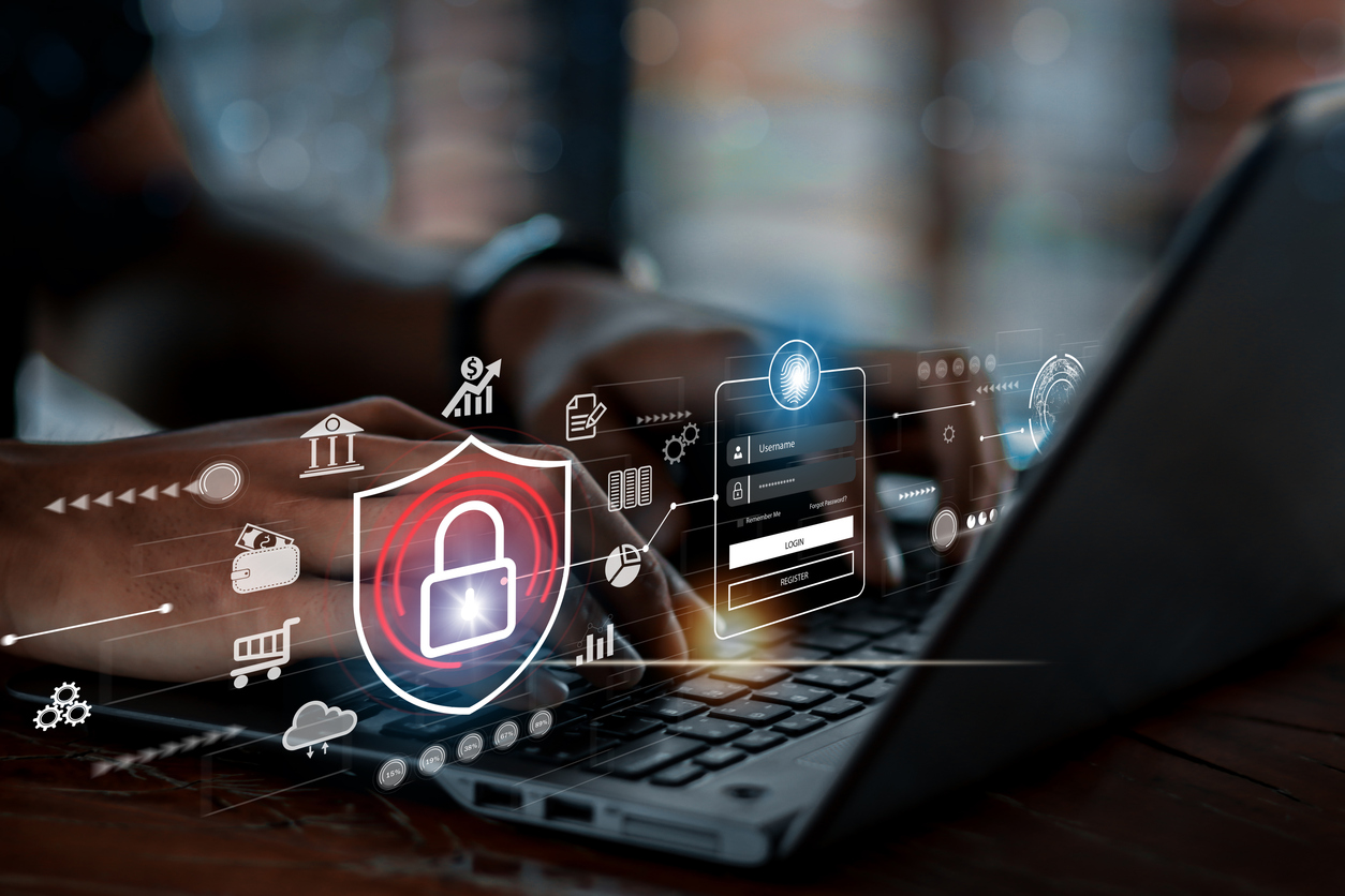 A businessman using a laptop showing cybersecurity protection against potential scams and threats.