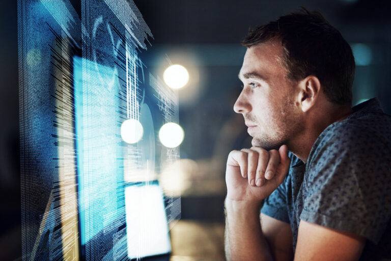 24/7 IT support - A male IT professional monitoring business operations through a computer screen.