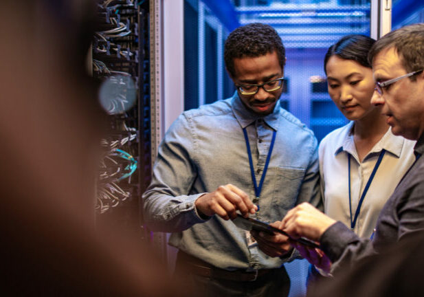 Software engineers working in IT companies, resolving problems in a company's server room.