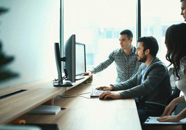 Benefits of outsourcing IT support - IT professionals discussing business operations in an office.