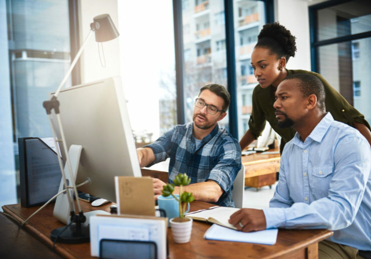 Switching MSPs - MSPs in an office using a computer while discussing services.